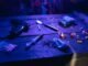 A moody scene displaying drugs, a gun, and smoke under dramatic lighting.