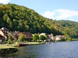 Charming riverside village of Beaulieu-sur-Dordogne, showcasing traditional French architecture along the Dordogne River in summer.