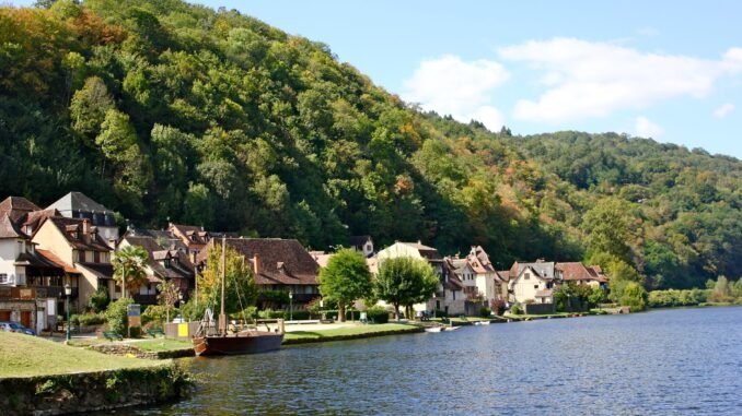 Charming riverside village of Beaulieu-sur-Dordogne, showcasing traditional French architecture along the Dordogne River in summer.