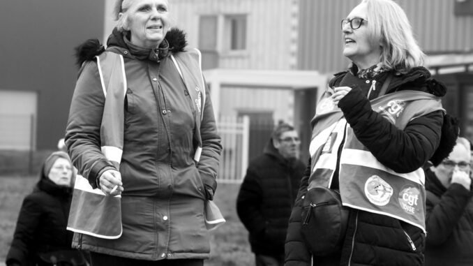 Black and white image of women in reflective vests participating in an outdoor protest.