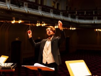 Orchestra conductor passionately leading a performance in an elegant concert hall.